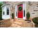 Close-up of a red front door with a wreath, flanked by bay windows and manicured shrubbery at 1470 Rhododendron Nw Dr, Acworth, GA 30102