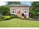 Charming brick home featuring a manicured front lawn, lush landscaping, and a bright red front door at 1470 Rhododendron Nw Dr, Acworth, GA 30102