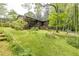 Backyard with ample greenery, a wooden fence, mature trees, and an upper-level patio at 2425 Maclaren Cir, Dunwoody, GA 30360