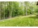 Large grassy backyard with chain-link fence and mature trees at 2425 Maclaren Cir, Dunwoody, GA 30360