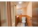 Cozy bathroom featuring a shower-tub combination, toilet, and wood-paneled walls at 2425 Maclaren Cir, Dunwoody, GA 30360