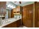 Bathroom featuring a double sink vanity, natural wood accents, and generous storage at 2425 Maclaren Cir, Dunwoody, GA 30360