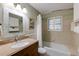 Bathroom with granite countertop, mosaic-trimmed mirror and tub with tiled wall at 2425 Maclaren Cir, Dunwoody, GA 30360