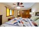 Bedroom with colorful quilt, ceiling fan, closet access, and decorative stained-glass window at 2425 Maclaren Cir, Dunwoody, GA 30360