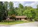 Brick single story home surrounded by shade trees and manicured lawn at 2425 Maclaren Cir, Dunwoody, GA 30360