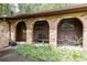Inviting brick archway leading to front porch with seating area and well-kept landscaping at 2425 Maclaren Cir, Dunwoody, GA 30360