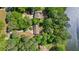 Aerial view of a wooded property with lake access and mature trees, highlighting privacy and natural beauty at 5159 Sw East Shore Sw Dr, Conyers, GA 30094