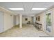 Finished basement area with tiled floor, neutral walls, fluorescent lighting and a door to the exterior at 5159 Sw East Shore Sw Dr, Conyers, GA 30094