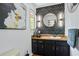 Stylish powder room with geometric wallpaper, round mirror, sconce lighting and black vanity at 5159 Sw East Shore Sw Dr, Conyers, GA 30094