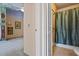View of a bathroom with tan tile flooring and shower with blue patterned shower curtain and safety bar at 5159 Sw East Shore Sw Dr, Conyers, GA 30094