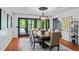 Bright dining room with wood floors, modern light fixture, table with seating for six and patio access at 5159 Sw East Shore Sw Dr, Conyers, GA 30094