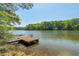 Lake view featuring a weathered dock surrounded by serene water and lush trees at 5159 Sw East Shore Sw Dr, Conyers, GA 30094