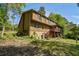 View of the side of the home with a wooden exterior, stairs, screened porch, and lush yard at 5159 Sw East Shore Sw Dr, Conyers, GA 30094