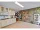 Kitchen with tile floors, white cabinetry, and stone accent wall with built-in oven at 5159 Sw East Shore Sw Dr, Conyers, GA 30094