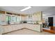 Kitchen with tile floor and countertops, white cabinetry and view of a dining area at 5159 Sw East Shore Sw Dr, Conyers, GA 30094
