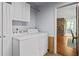 Bright laundry room with side-by-side washer and dryer, and a view into the kitchen at 5159 Sw East Shore Sw Dr, Conyers, GA 30094