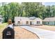 A quaint home is pictured with its long driveway, mailbox, and fresh landscaping at 783 Britt Sw Rd, Mableton, GA 30126