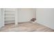 Finished basement area with neutral paint, wood-look flooring, built-in shelving and stairs at 1213 Anderson Mill Rd, Austell, GA 30106