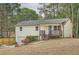 Charming home with a covered front porch, steps, and an inviting blue door nestled amongst mature trees at 1213 Anderson Mill Rd, Austell, GA 30106