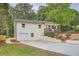 Charming house with an attached garage, covered porch, concrete driveway, and a blue front door at 1213 Anderson Mill Rd, Austell, GA 30106