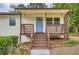 Up close front porch with wood detail, blue door and rose bush at 1213 Anderson Mill Rd, Austell, GA 30106