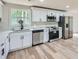 Kitchen features stainless steel appliances, white cabinets, countertops and wood-look flooring at 1213 Anderson Mill Rd, Austell, GA 30106