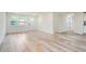 Bright living room featuring modern wood-look floors, white walls, and a white door to outside at 1213 Anderson Mill Rd, Austell, GA 30106