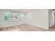 Bright living room featuring modern wood-look floors, white walls, and a white door at 1213 Anderson Mill Rd, Austell, GA 30106
