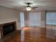 Bright living room with hardwood floors, a brick fireplace, and large windows with sunlight streaming in at 1511 Harbor Watch Ct, Woodstock, GA 30189