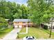 Aerial view of house featuring a two-car garage, surrounded by lush greenery, complemented by a well-manicured lawn at 1563 Greenwood Dr, Norcross, GA 30093