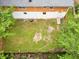 Aerial view of the backyard reveals a combination of lush grass and uncultivated areas, and the rear of the house at 1563 Greenwood Dr, Norcross, GA 30093