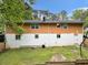 The exterior back of the home features a two-toned paint job and a large backyard at 1563 Greenwood Dr, Norcross, GA 30093