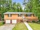 Charming home featuring brick accents, a two-car garage, and a welcoming entrance in a lush, green setting at 1563 Greenwood Dr, Norcross, GA 30093