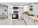 Kitchen with white cabinets, tan countertops, and stainless steel sink with tiled floors at 1563 Greenwood Dr, Norcross, GA 30093