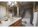 Bathroom with a single sink vanity, tile floors, and a tub-shower with curtains at 3127 Lenox Ne Rd # 1, Atlanta, GA 30324