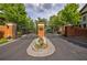 Gated community entrance featuring brick pillars, manicured flower bed, and black wrought iron gates at 3127 Lenox Ne Rd # 1, Atlanta, GA 30324