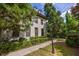 Home exterior with brick siding, dark shutters, lush trees, and a sidewalk at 3127 Lenox Ne Rd # 1, Atlanta, GA 30324