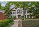 Elegant two-story home with a stone facade, manicured landscaping, and a charming balcony above the front door at 3127 Lenox Ne Rd # 1, Atlanta, GA 30324