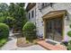 Home exterior with a brick entryway, double doors, lush landscaping, and sidewalk at 3127 Lenox Ne Rd # 1, Atlanta, GA 30324
