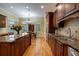 An open-concept kitchen features an island with granite countertops and custom wooden cabinetry at 3127 Lenox Ne Rd # 1, Atlanta, GA 30324