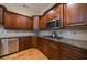 Kitchen featuring granite countertops, stainless steel appliances, gas range, and wooden cabinets at 3127 Lenox Ne Rd # 1, Atlanta, GA 30324