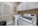 Bright laundry room with white washer, dryer, cabinets, and a louvered door at 3127 Lenox Ne Rd # 1, Atlanta, GA 30324