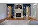 Living room with fireplace, mounted tv and adjacent arched entryway to stairs with tiled landing at 3127 Lenox Ne Rd # 1, Atlanta, GA 30324