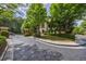 Wide street view of a gated community entrance with lush landscaping and a sidewalk at 3127 Lenox Ne Rd # 1, Atlanta, GA 30324