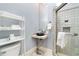 Bathroom featuring elegant sink with decorative stand, open shelving, and a glass-enclosed tile shower at 865 Ashland Ne Ave, Atlanta, GA 30307