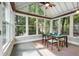 Bright sunroom featuring large windows offering wooded views and a table seating four at 865 Ashland Ne Ave, Atlanta, GA 30307