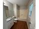 Bathroom featuring white cabinets, granite countertops, shower and tub combination, and wood look floors at 1231 Providence Way, Lawrenceville, GA 30046