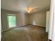 This bedroom features neutral walls, carpeted floors, a ceiling fan, and a window with tree views at 1231 Providence Way, Lawrenceville, GA 30046