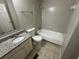 Well-lit bathroom features a granite countertop, tiled floor, and shower-tub combo at 2036 Countydown Ln, Stone Mountain, GA 30088