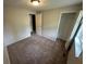 This carpeted bedroom features a closet and adjacent bathroom and bedroom at 2036 Countydown Ln, Stone Mountain, GA 30088